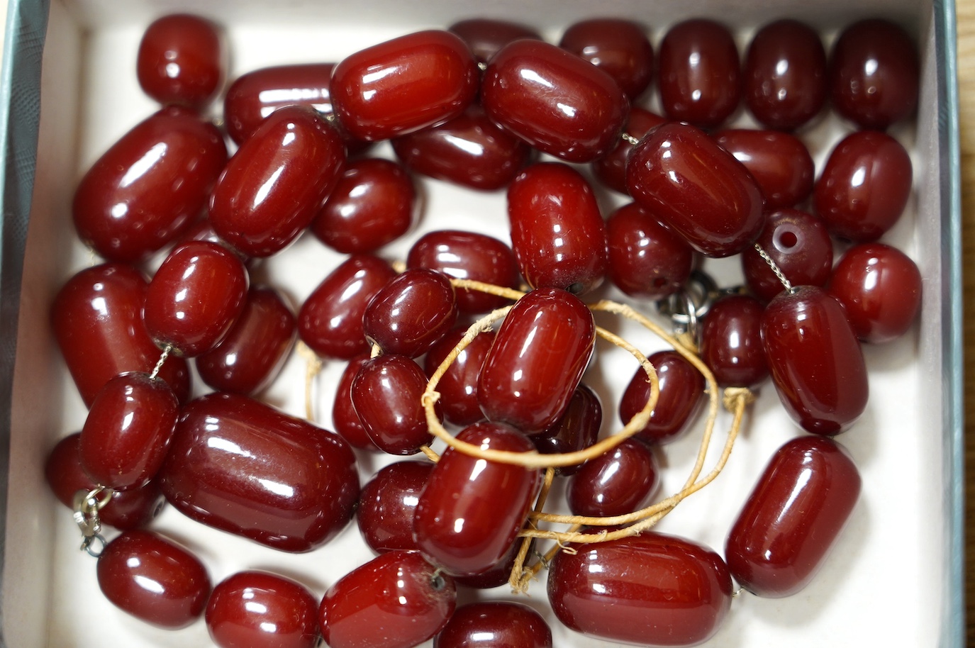 A simulated cherry amber bead necklace, (needs re-stringing), gross weight 136 grams. Condition - poor